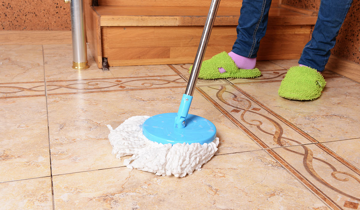 woman-cleaning-tile-floor-installed-by-BK-Flooring-Services