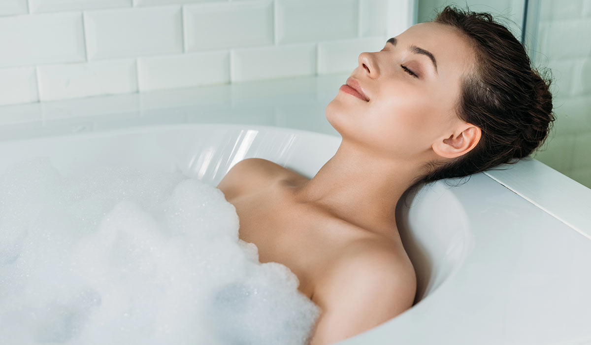 young-woman-relaxing-in-tile-bathroom-BK-Flooring-Services